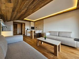 a living room with a couch and a table at Magnifique attique avec vue sur le lac de la Moubra in Crans-Montana