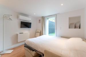 Habitación blanca con cama y ventana en Studios Le Médicis, en Rouen