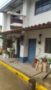 un edificio con una puerta azul y macetas en Hospedaje Quillabamba, en Santa Teresa