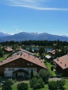 an aerial view of a house with a lake and mountains at Magnifique attique avec vue sur le lac de la Moubra in Crans-Montana