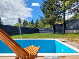 una sedia in legno seduta accanto alla piscina di Orange Villa with private pool a Ilidža