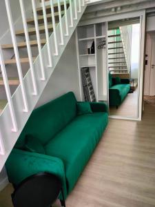 a green couch in a living room with stairs at Apartament Paradise Zarządzany przez gospodarza osobę fizyczną Self check in in Rzeszów