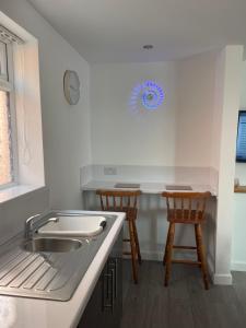 una cucina con lavandino e 2 sgabelli in legno di San Remo Apartments Blackpool a Blackpool