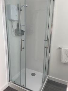 una doccia con porta in vetro in bagno di San Remo Apartments Blackpool a Blackpool