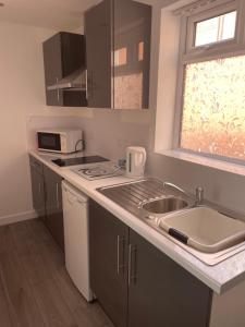 una piccola cucina con lavandino e forno a microonde di San Remo Apartments Blackpool a Blackpool