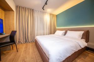 um quarto com uma grande cama branca e uma secretária em Blloku Unique Apartments 2 em Tirana