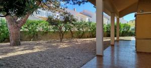 a courtyard with a tree and a building at Beach House Villa At Peniche - Praia Consolação in Atouguia da Baleia