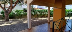 a walkway leading to a building with a tree at Beach House Villa At Peniche - Praia Consolação in Atouguia da Baleia