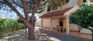 a building with a tree in front of it at Beach House Villa At Peniche - Praia Consolação in Atouguia da Baleia