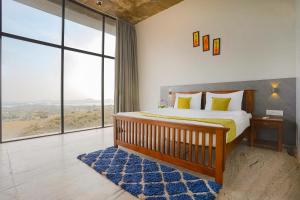 una camera con un letto e una grande finestra di Wabi Sabi Resort, Igatpuri a Igatpuri