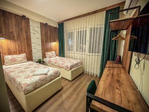 pokój hotelowy z 2 łóżkami i stołem w obiekcie Calla Bella Rooms & Snack Bar w mieście Skopje