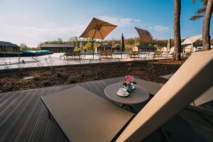 - une table avec une tasse de café et des fleurs sur une terrasse dans l'établissement Folga Resort, à Mrzeżyno