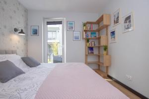 1 dormitorio con cama y estante para libros en Apartament Terenia, en Puck