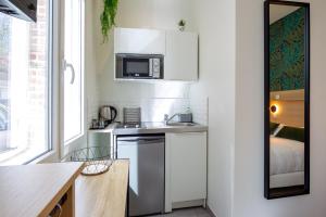 een kleine keuken met een wastafel en een magnetron bij Appartement 1 proche de la gare et du centre ville in Amiens