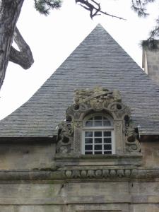 an ornate window on the side of a building at Chateau de Courseulles in Courseulles-sur-Mer