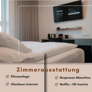 Cette chambre comprend un lit et une télévision murale. dans l'établissement City Rooms Amstetten, à Amstetten