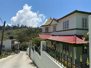 una casa con una recinzione sul lato di una strada di AppleCreek a Kodaikānāl