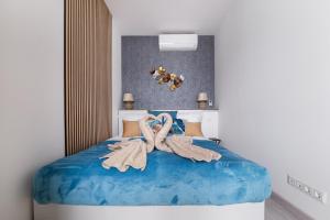 een slaapkamer met een blauw bed en handdoeken bij Rames-Cosmo Downtown Apartment with rooftop POOL in Boedapest