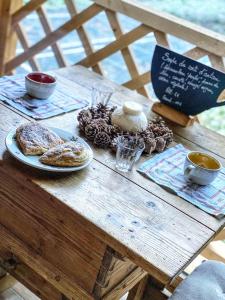 une table en bois avec des assiettes de nourriture dans l'établissement 1000 Borne Caffe Hebergements Insolites, à Entremont