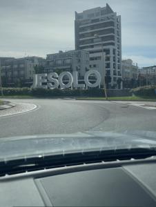 um carro a descer uma estrada em frente a um edifício em Attico Sole em Lido di Jesolo