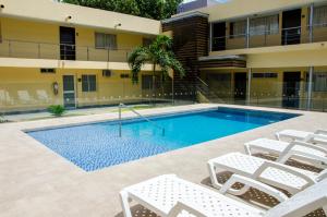 una piscina con sillas y un edificio en Hotel Arizona Suites Cúcuta, en Cúcuta