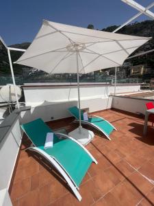 einen Balkon mit 2 Stühlen und einem Sonnenschirm in der Unterkunft Casa Positano in Positano