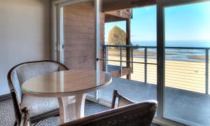 uma mesa e cadeiras num quarto com vista para o oceano em Hallmark Resort in Cannon Beach em Cannon Beach