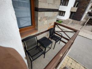 two chairs and a table on a balcony at Апартамент Four Seasons in Bansko