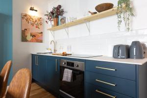 een blauwe keuken met een wastafel en een vaatwasser bij Regency Grade II Listed Townhouse by Centre and Beach in Brighton & Hove