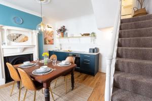 een eetkamer met een tafel en stoelen en een trap bij Regency Grade II Listed Townhouse by Centre and Beach in Brighton & Hove