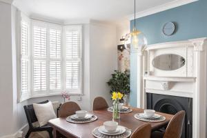 een eetkamer met een tafel en stoelen en een open haard bij Regency Grade II Listed Townhouse by Centre and Beach in Brighton & Hove