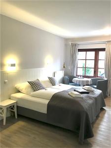 - une chambre avec un grand lit et un salon dans l'établissement Landhaus Nordstern Hotel garni, à Utersum