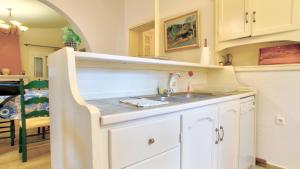 a kitchen with white cabinets and a sink at Villa Vivere in Corfu Town