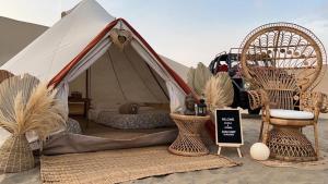 Tienda con 2 sillas y 1 cama en el desierto en Duna Camp Huacachina, en Ica