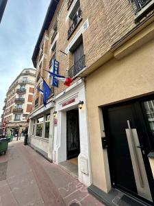 ein Gebäude mit einem Straßenschild auf der Seite in der Unterkunft Hotel Victor Hugo in Clamart