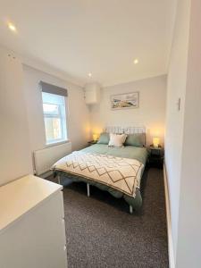 um quarto com uma cama e uma janela em Bournemouth Beach Apartment em Bournemouth