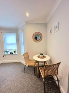 um quarto com uma mesa e cadeiras e uma janela em Bournemouth Beach Apartment em Bournemouth