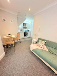 uma sala de estar com um sofá verde e uma mesa em Bournemouth Beach Apartment em Bournemouth