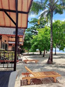 eine Gruppe Picknickbänke vor einem Gebäude in der Unterkunft Beach House Penida in Nusa Penida