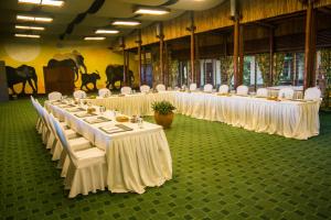 una fila de mesas con sillas blancas en una habitación en Kilaguni Serena Safari Lodge, en Tsavo