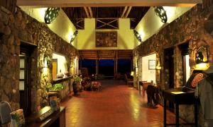 una habitación con paredes de piedra y una habitación con perros. en Kilaguni Serena Safari Lodge, en Tsavo