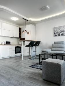 ein Wohnzimmer mit einem Tisch und einer Küche in der Unterkunft Apartman Spaß in Šabac