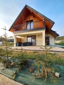 une maison avec un balcon au-dessus d'une cour dans l'établissement Domek na Hubce II, à Maniowy