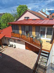 a house with a deck with a red roof at Várfal apartman II in Eger