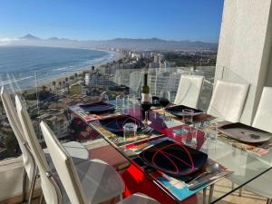 a table with a bottle of wine and chairs on a balcony at La Choza VIP Roja in Coquimbo