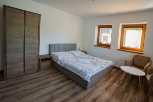 - une petite chambre avec un lit et une chaise dans l'établissement Chata Dolný Smokovec Správa TANAPu, à Dolný Smokovec