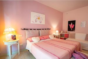 1 dormitorio con 1 cama grande y paredes de color rosa en Petali Rosa, en Polignano a Mare