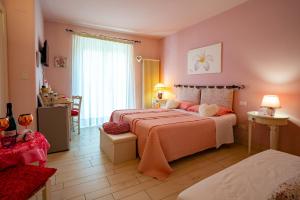 1 dormitorio con 2 camas y paredes de color rosa en Petali Rosa, en Polignano a Mare