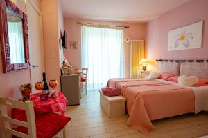 1 dormitorio con 2 camas, mesa y sillas en Petali Rosa, en Polignano a Mare