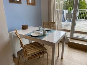 mesa de comedor blanca con sillas y ventana en City Wohnung mit Gartenblick und Dachterrasse, en Verden